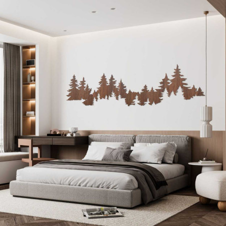 Close-up view of a forest silhouette made of wood mounted on a white wall.