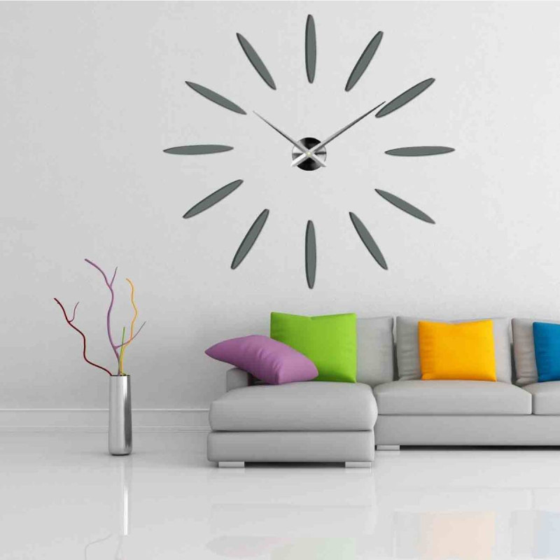 Wall clock in a gold design, with long, slender hands and no classic dial.