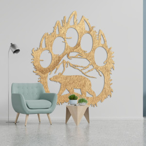 A wooden image of a bear footprint, inside of which is carved the silhouette of a bear walking under the mountains.