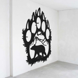 A close-up view of a natural motif of a bear and mountains inside a large wooden paw.