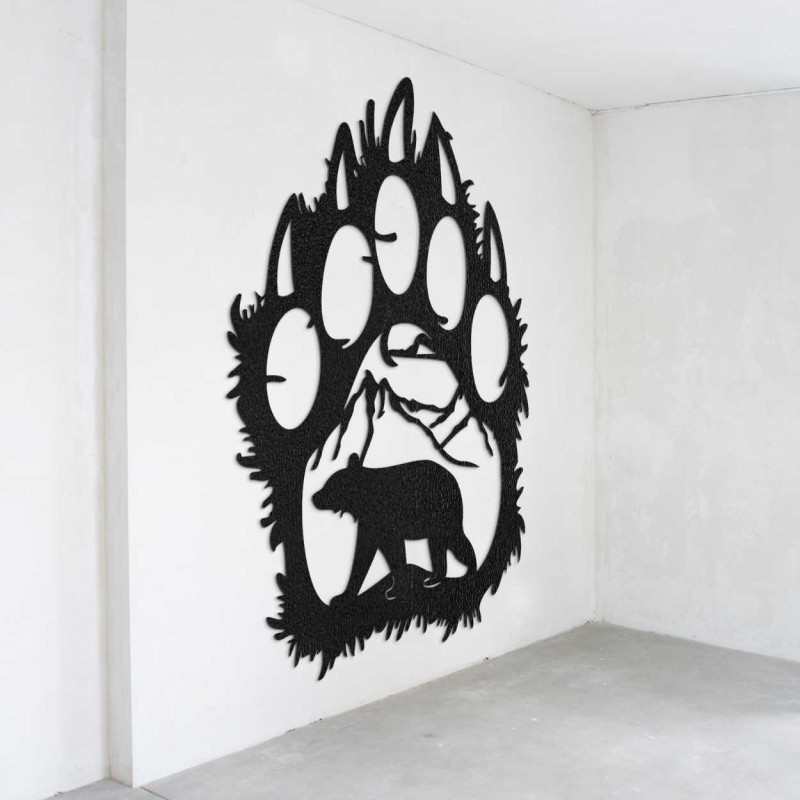 A close-up view of a natural motif of a bear and mountains inside a large wooden paw.