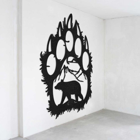 A close-up view of a natural motif of a bear and mountains inside a large wooden paw.