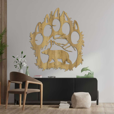 Hand-carved decoration depicting a bear walking under a mountain range.