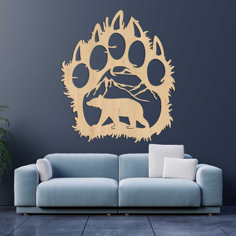 A wooden wall painting combining the shape of a bear footprint with a mountain landscape.