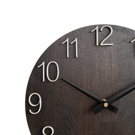 Wooden wall clock with carved numbers and metal hands.