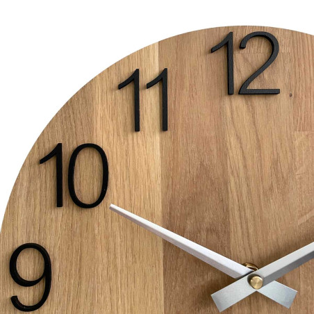 Round clock made of natural wood with contrasting metal hands. Round clock made of natural wood with contrasting metal hands.
