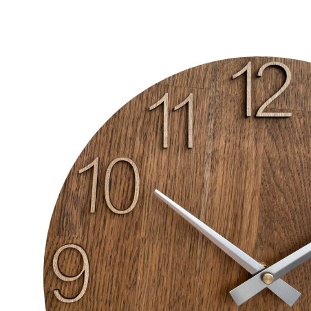 Wooden wall clock with a circular shape and a subtle natural motif.