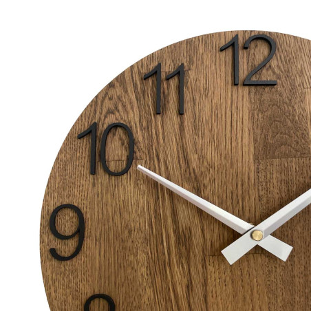 Round clock with a decorative cutout in the center and a delicate wood pattern.