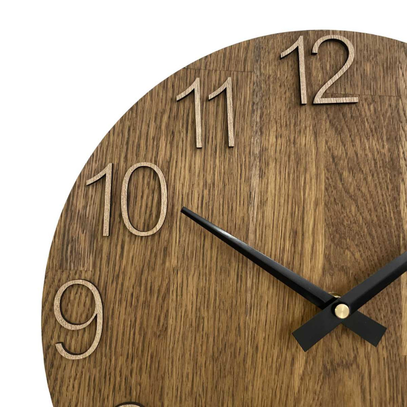 Wooden clock with a symmetrical shape and a cutout inspired by motifs from nature.