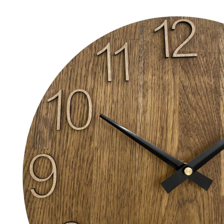 Wooden clock with a symmetrical shape and a cutout inspired by motifs from nature.