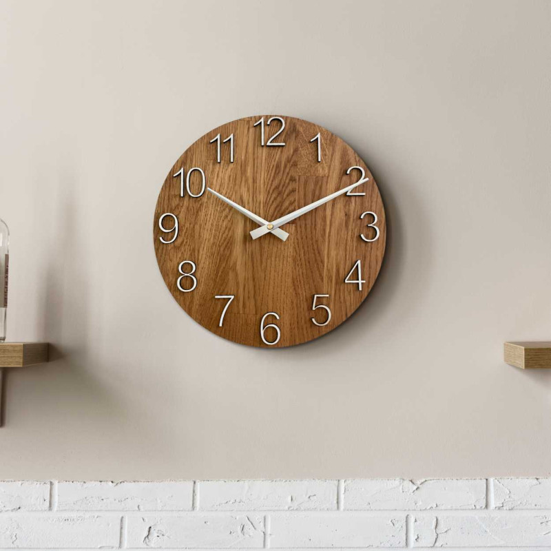 Wooden wall clock with a circular shape and a subtle natural motif.