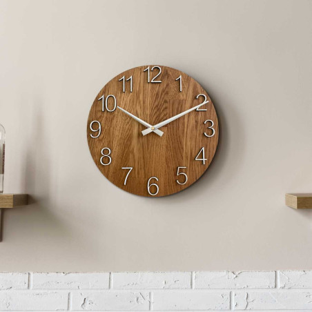 Wooden wall clock with a circular shape and a subtle natural motif. Wooden wall clock with a circular shape and a subtle natural motif.