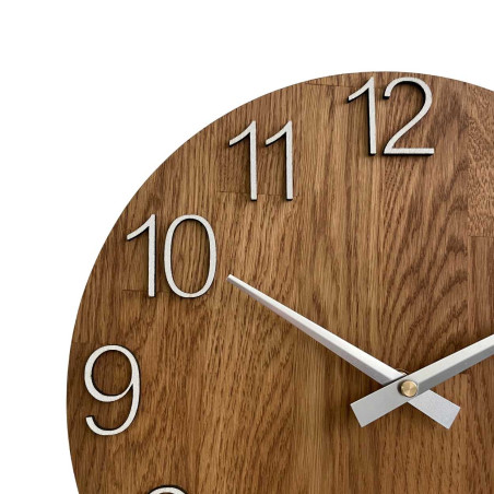 Round clock made of natural wood with contrasting metal hands. Round clock made of natural wood with contrasting metal hands.