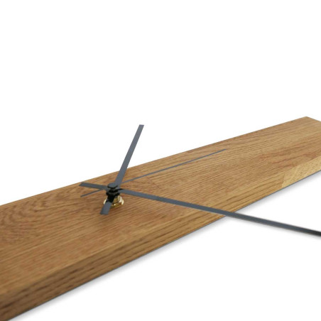 Minimalist wooden clock in the shape of a narrow panel with silver and black hands. Minimalist wooden clock in the shape of a narrow panel with silver and black hands.