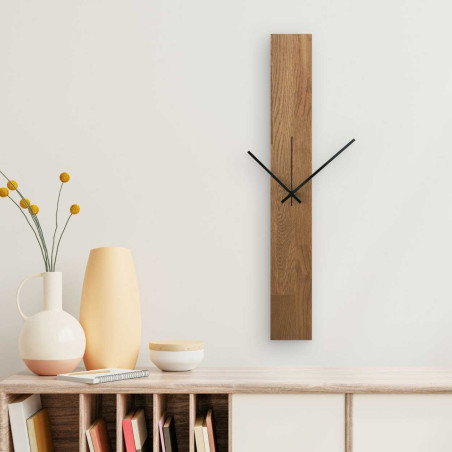 Wall clock with a narrow wooden panel and hands in black and silver. Wall clock with a narrow wooden panel and hands in black and silver.