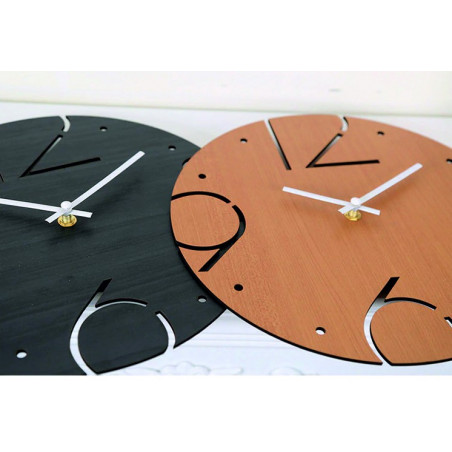 A clock made of solid material with a smooth surface and contrasting arrangement of elements. A clock made of solid material with a smooth surface and contrasting arrangement of elements.
